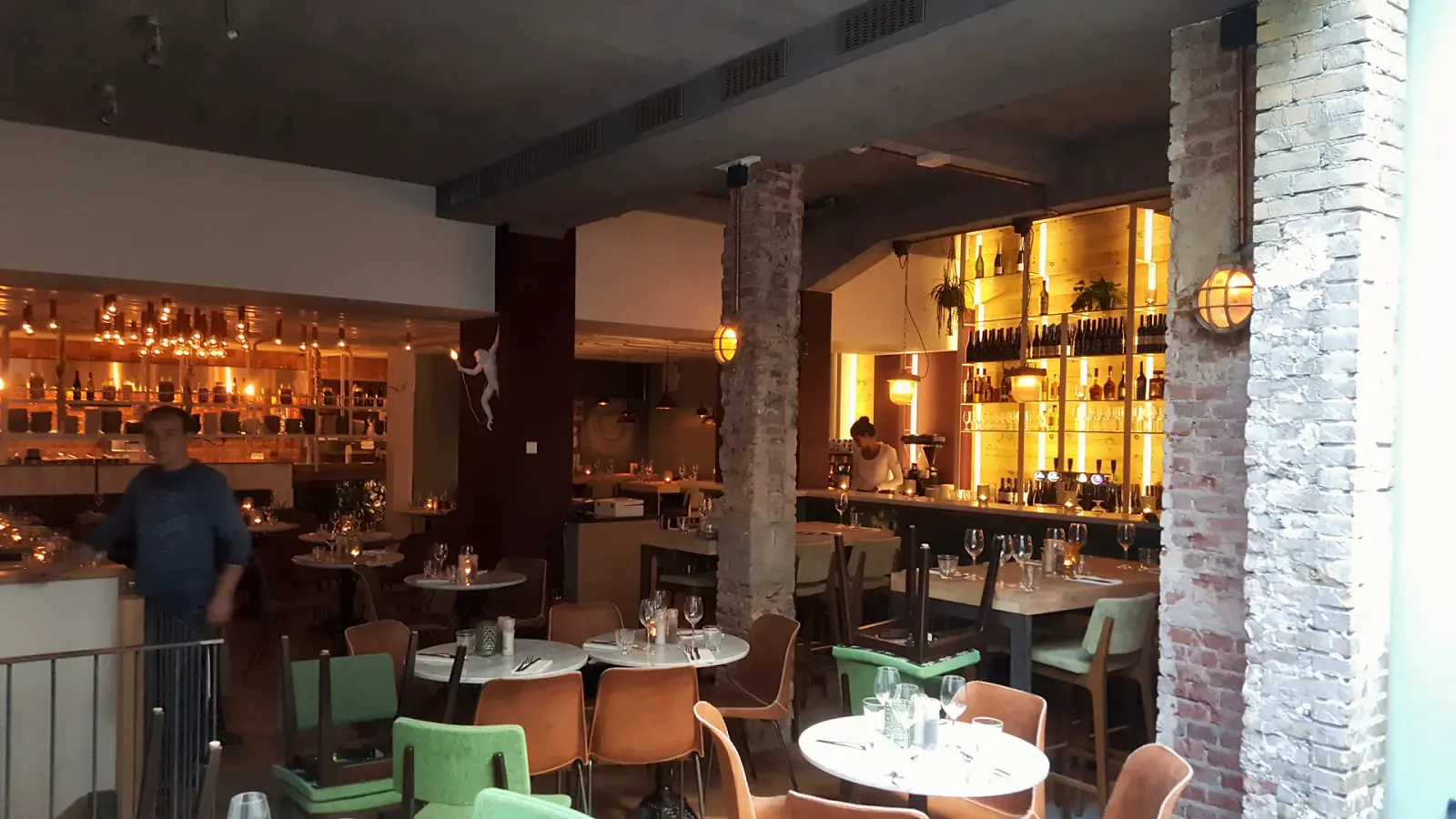 Restaurantzaal met verlichte stalen wandrekken in restaurant Kleine Parade