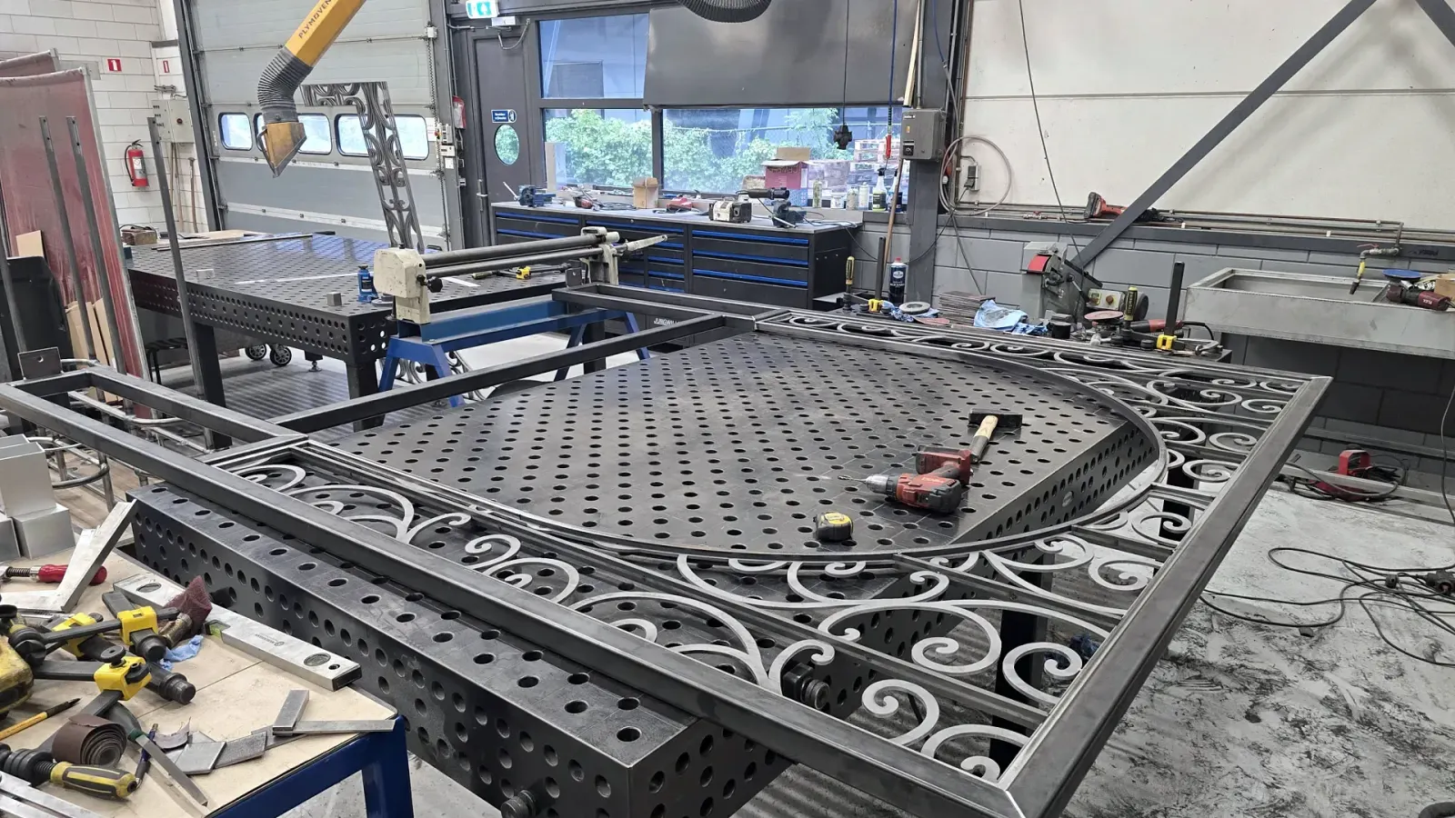 Smeedijzeren ornamentpaneel op de lastafel in de werkplaats van AVASTO in Oudewater