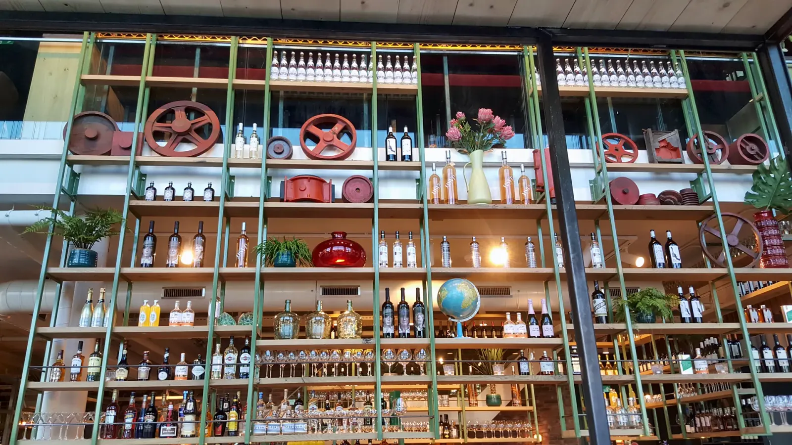 Groene stalen flessenwand met decoratie, Metro City Kitchen, Utrecht