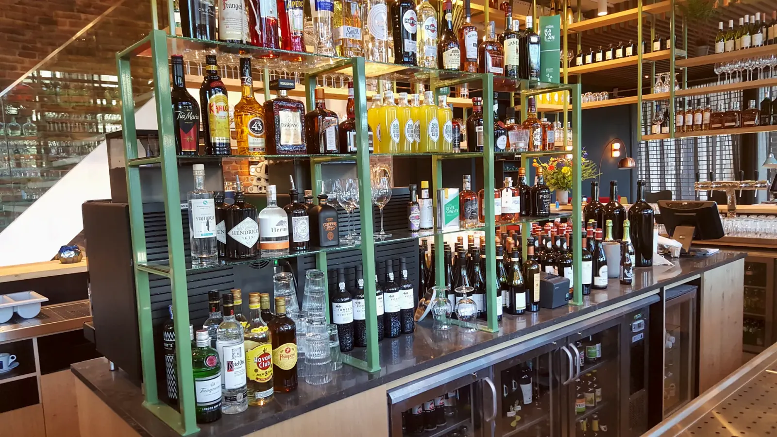 Vrijstaand groen stalen flessenrek bij de bar, Metro City Kitchen, Utrecht