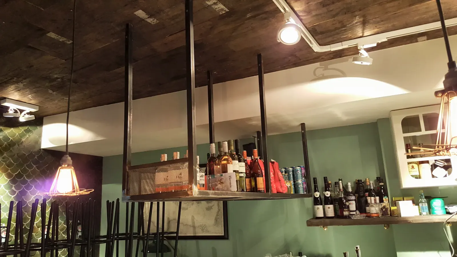 Stalen ophangrek met flessen boven de bar, Sea Salt, Utrecht