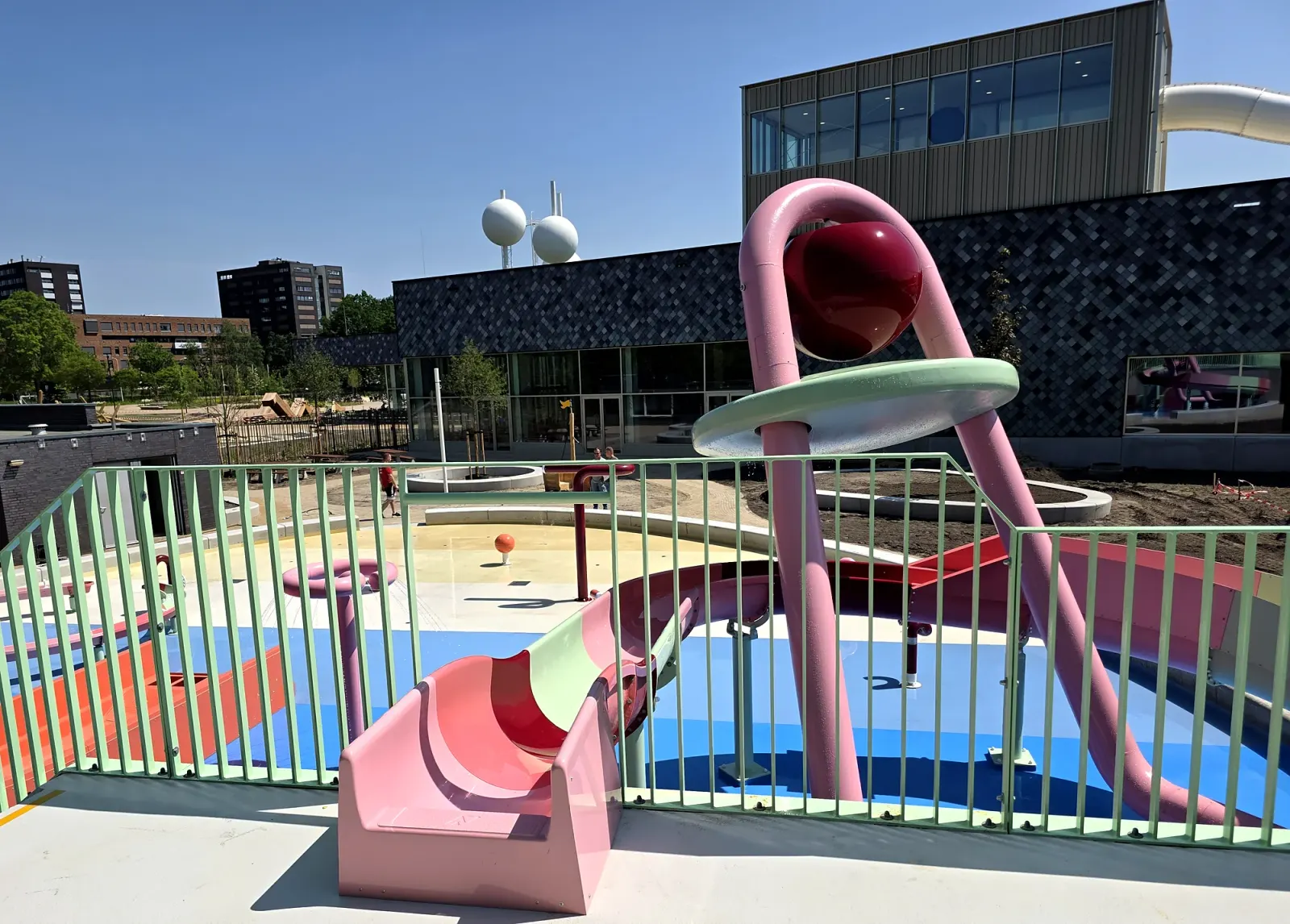 Roze glijbaan en speeltoren in het buitenspraypark van De Tongelreep