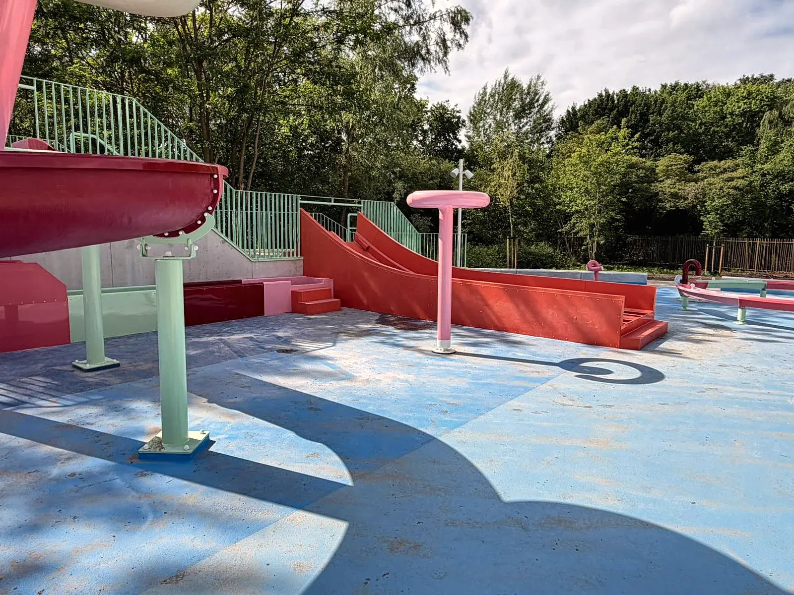 Overzicht van het buitenspraypark van De Tongelreep met glijbanen en sproeiers